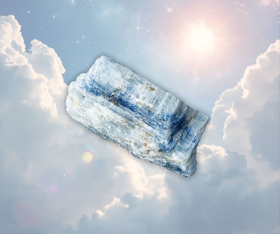 Pierre brute de cyanite bleue aux reflets argentés sur fond de ciel lumineux, symbole de clarté mentale, d’équilibre énergétique et de communication intérieure – Aura Cristal