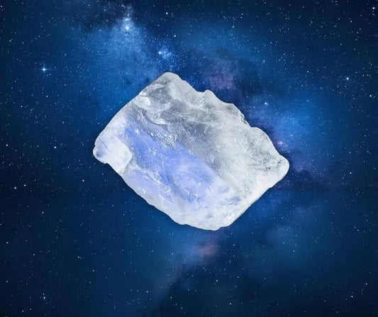 Pierre brute de pierre de lune blanche aux reflets bleutés sur fond étoilé, symbole de féminité, d’intuition et d’équilibre émotionnel – Aura Cristal