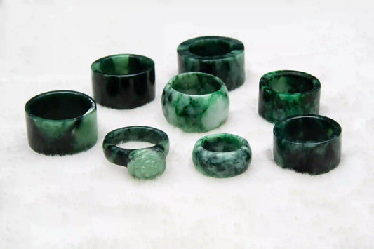 Bagues et bijoux en jade vert disposés sur une surface claire, symbole de sérénité, de prospérité et d’harmonie intérieure – Aura Cristal