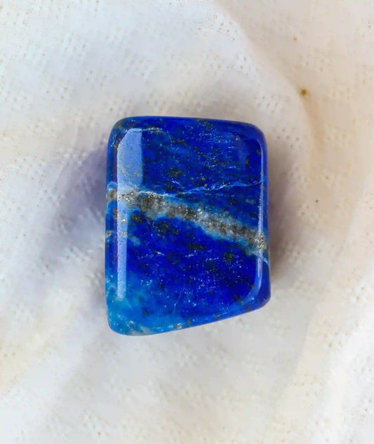 Pierre roulée de lapis-lazuli bleu profond avec veine blanche, symbole de sagesse, d’intuition et de communication authentique – Aura Cristal