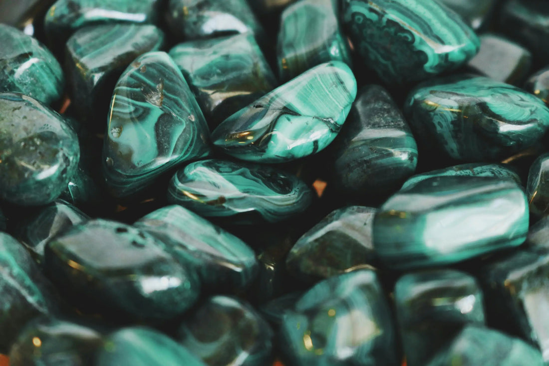 Pierres roulées de malachite verte aux motifs concentriques, symbolisant la transformation, la protection émotionnelle et l’équilibre du cœur – Aura Cristal