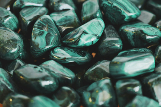 Pierres roulées de malachite verte aux motifs concentriques, symbolisant la transformation, la protection émotionnelle et l’équilibre du cœur – Aura Cristal