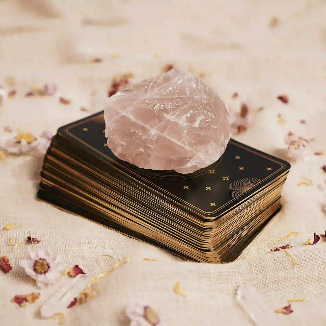 Pierre de quartz rose posée sur un jeu de cartes spirituelles, symbole d’amour, d’intuition et d’énergie apaisante – Aura Cristal