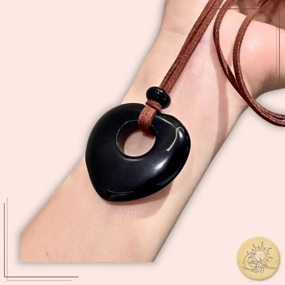 Collier long cœur creux en Obsidienne noire, pierre naturelle taillée et polie, finition brillante sur cordon marron, bijou de protection énergétique et d’assurance Aura Cristal.