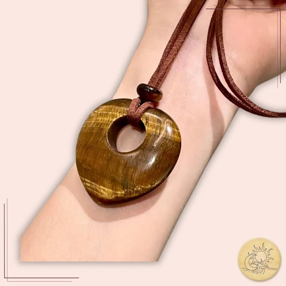 Collier long cœur creux en Œil de Tigre, pierre naturelle taillée et polie, nuances dorées et brunes chatoyantes, sur cordon marron, talisman de force, de courage et d’élégance spirituelle Aura Cristal.