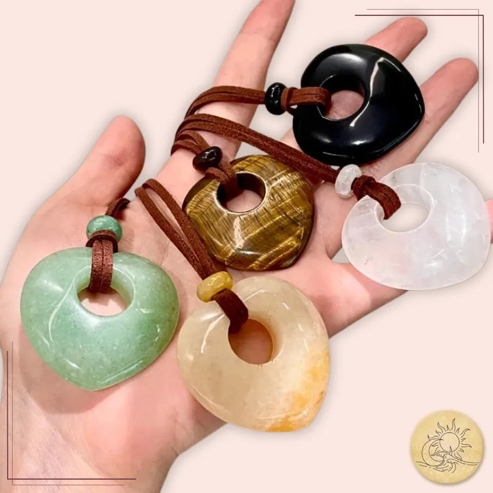 Ensemble de colliers longs cœur creux en pierres naturelles (aventurine, cristal de roche, jaspe jaune, obsidienne et œil de tigre), pendentifs taillés et polis, sur cordons marron, symboles d’élégance et de protection spirituelle Aura Cristal.